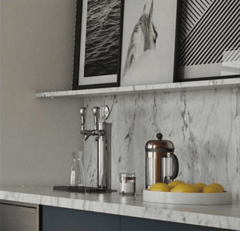 Sleek counter with water dispenser and bowl of lemons. Above is a shelf with three black and white photographs.